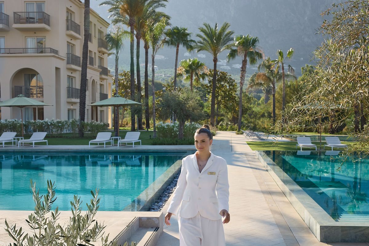 Grecotel female employee  walking at the pool site of Grecotel Philoxenia in Kalamata Greece